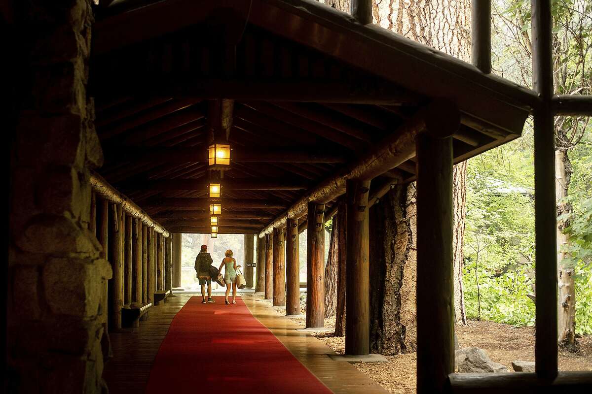 FILE - In this July 25, 2018 file photo, guests leave the The Majestic Yosemite Hotel?, formerly The Ahwahnee Hotel, shortly after it closed in Yosemite National Park, Calif. Yosemite National Park will reopen Tuesday, Aug. 14, 2018, 14 days after a wildfire choked the park with smoke at the peak of tourist season. Park spokesman Scott Gediman said Friday, Aug. 10, visitors should expect limited hours and visitor services as the park returns to normal. The scenic Yosemite Valley and other areas have been closed since July 25 along with hundreds of campsites and hotels. Though the blaze didn't reach the heart of the valley, it burned in remote areas of the park about 250 miles (400 kilometers) from San Francisco, making roads inaccessible and polluting the air with smoke. (AP Photo/Noah Berger, File)