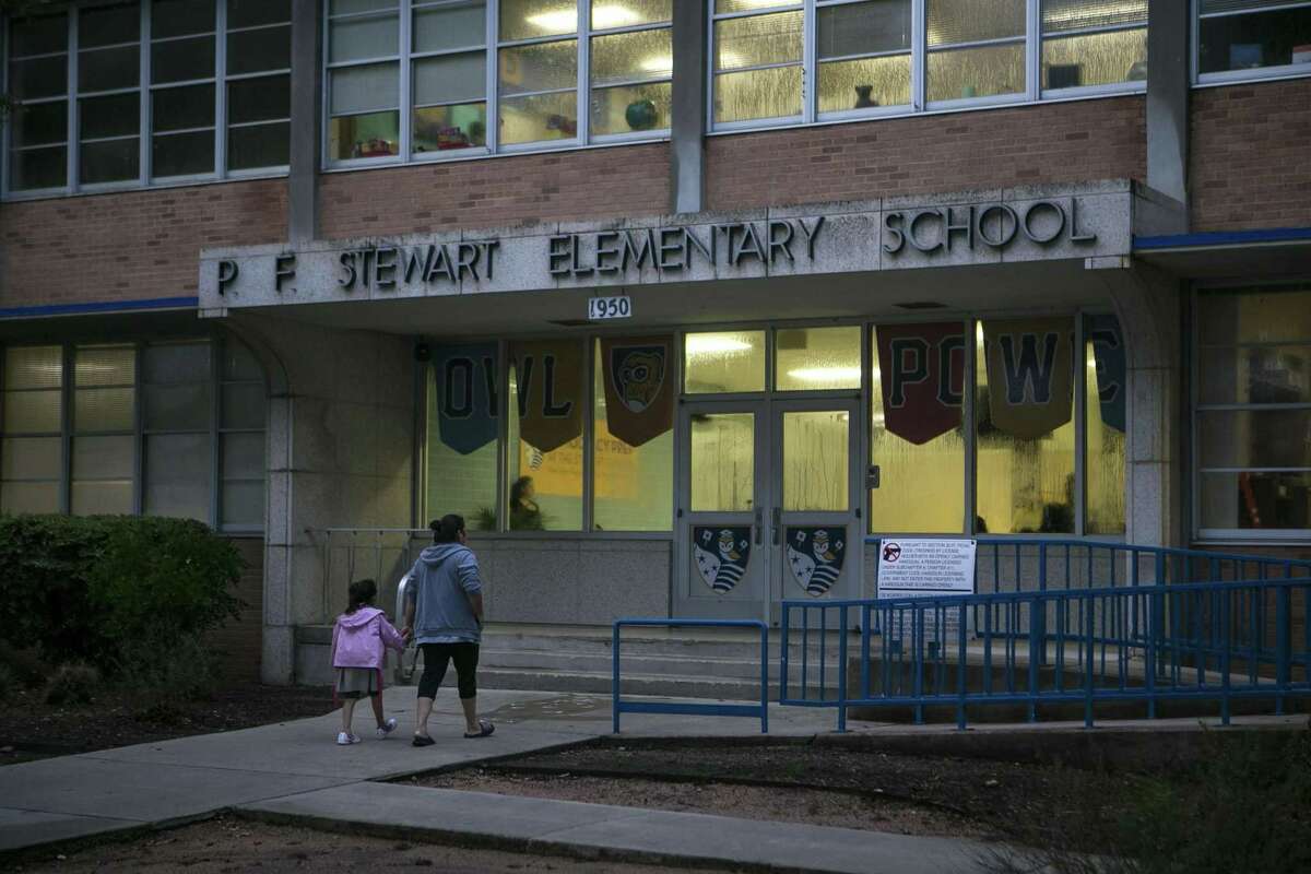 A mother walks her daughter into school on the first day of class at Democracy Prep at the Stewart Campus Aug. 13, 2018. The school is run by the New York-based Democracy Prep charter network while remaining an SAISD school.