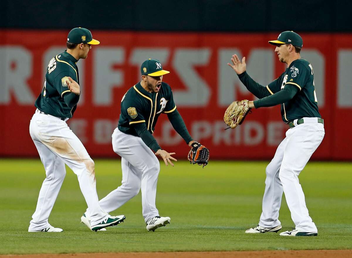 Oakland Athletics' Chad Pinder, Ramon Laureano and Stephen Piscotty celebrate A's 7-6 win over Seattle Mariners in MLB game at Oakland Coliseum in Oakland, Calif. on Monday, August 13, 2018.