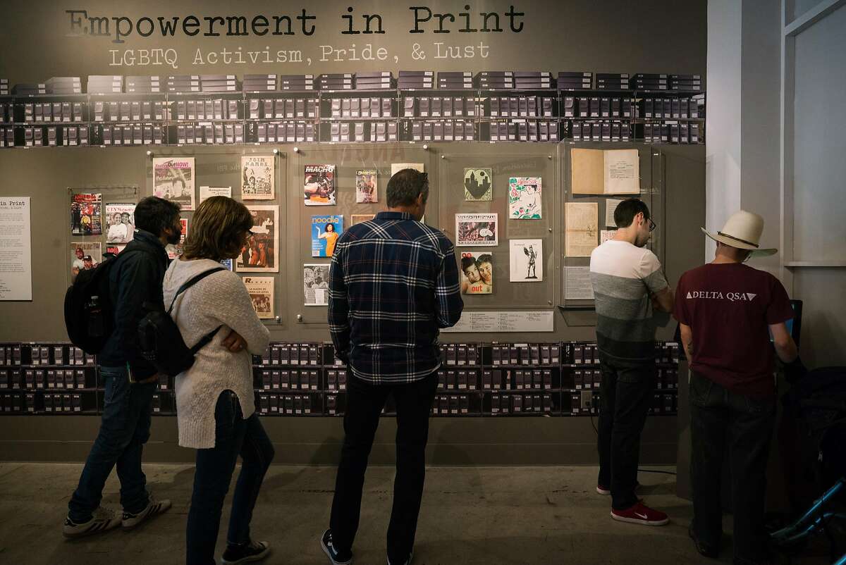 People look at historical publications from the LGBTQ community at the GLBT History Museum in San Francisco, Calif. on Monday, August 13, 2018. The exhibit uses archival materials and artifacts to share historical events of the GLBT community in San Francisco.