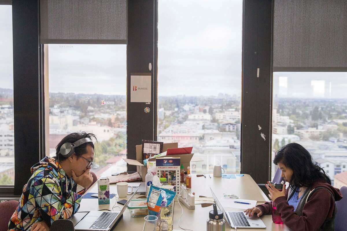 Two members of the startup Bungee work at their desks inside UC Berkeley's SkyDeck startup incubator in Berkeley, Calif. Tuesday, Aug. 14, 2018.