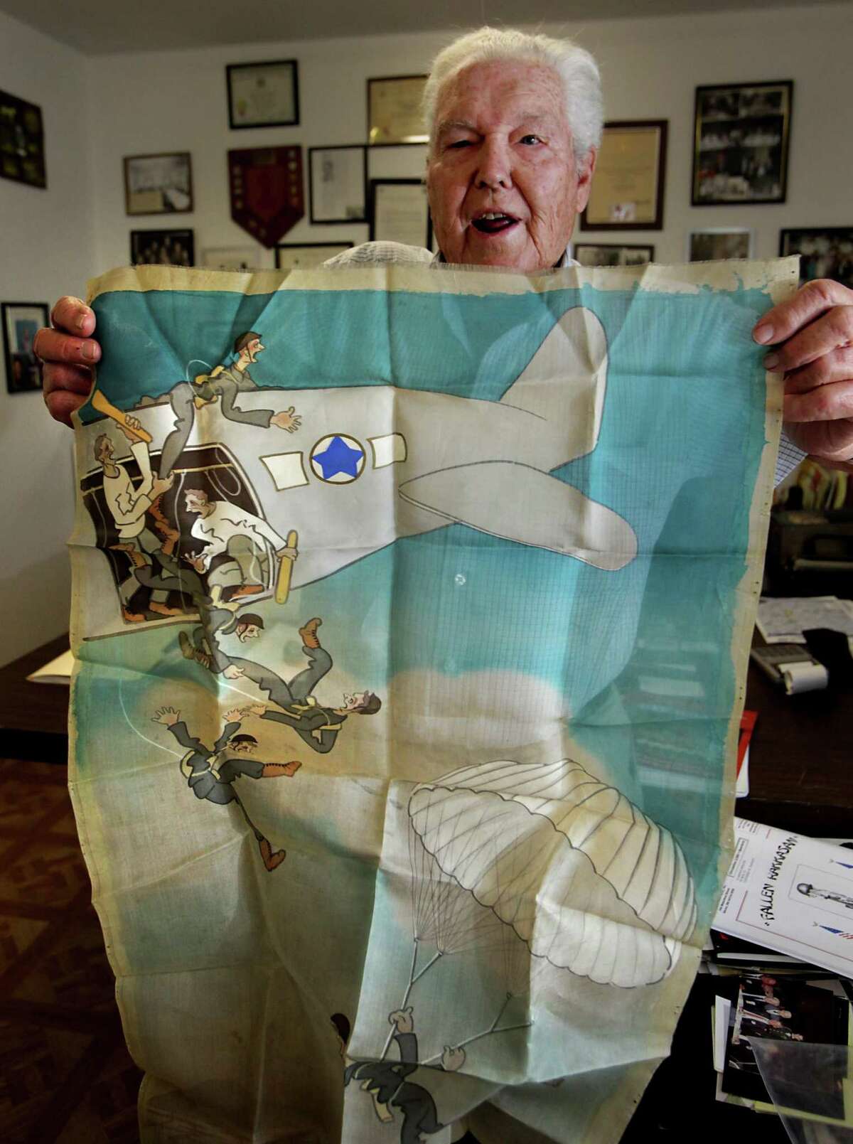 Metro adv - Retired Army Capt. Clarence Sprouse, holding up a Japanese military propaganda poster printed on silk, recalls his days fighting in WWII, Korea, Vietnam, and as trainer for the Cuban Bay of Pigs. The poster insinuates the U.S. forced soldiers to serve in the army. Sprouse has been called "The Perfect Soldier" by some of his superiors. Friday, Oct. 14, 2011. Photo Bob Owen/rowen@express-news.net