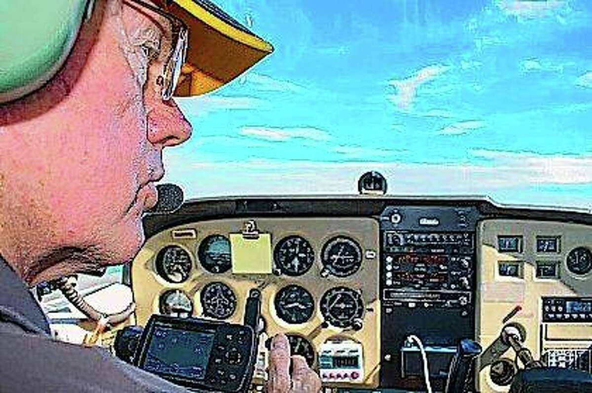 FILE - Pilot Neil Fotzler talks to the air traffic controller at Willard Airport during a flight in Savoy.