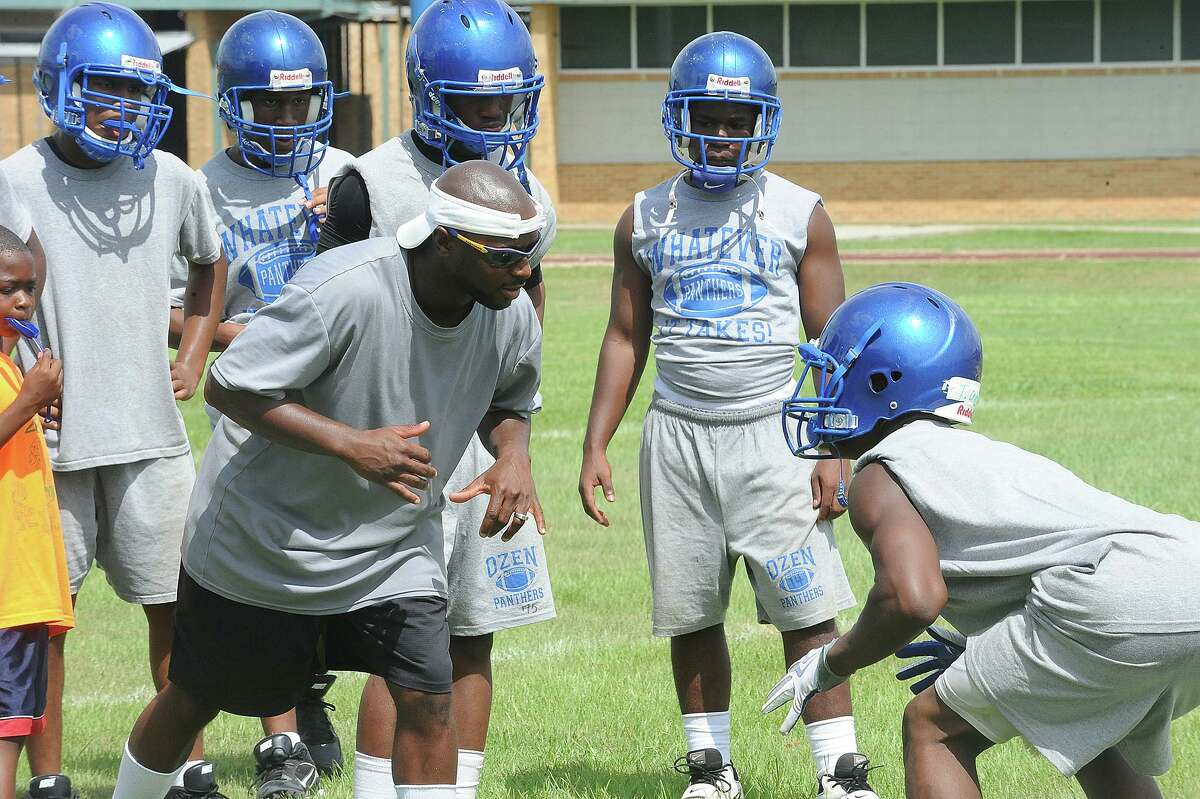 Ozen's Freddie Strange demonstrates positioning to players during the Panther's first day of practice on Monday. Guiseppe Barranco/The Enterprise