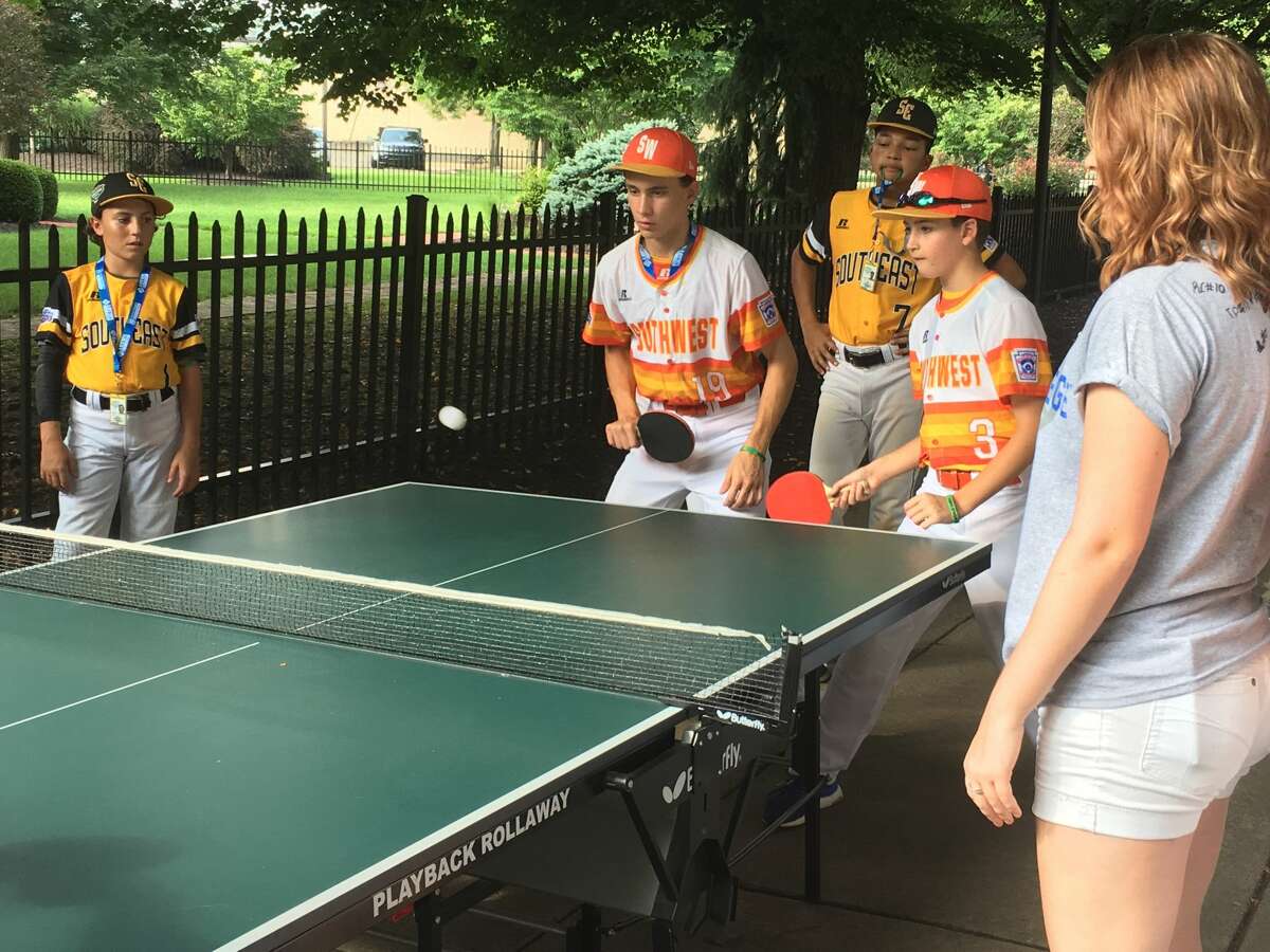 Post Oak Little League's Ryan Selvaggi (left) and Ethan Goldstein team up for a game of ping pong while players from Peachtree City, Georgia watch on Wednesday, Aug. 15, 2018 at Williamsport, Pennsylvania.