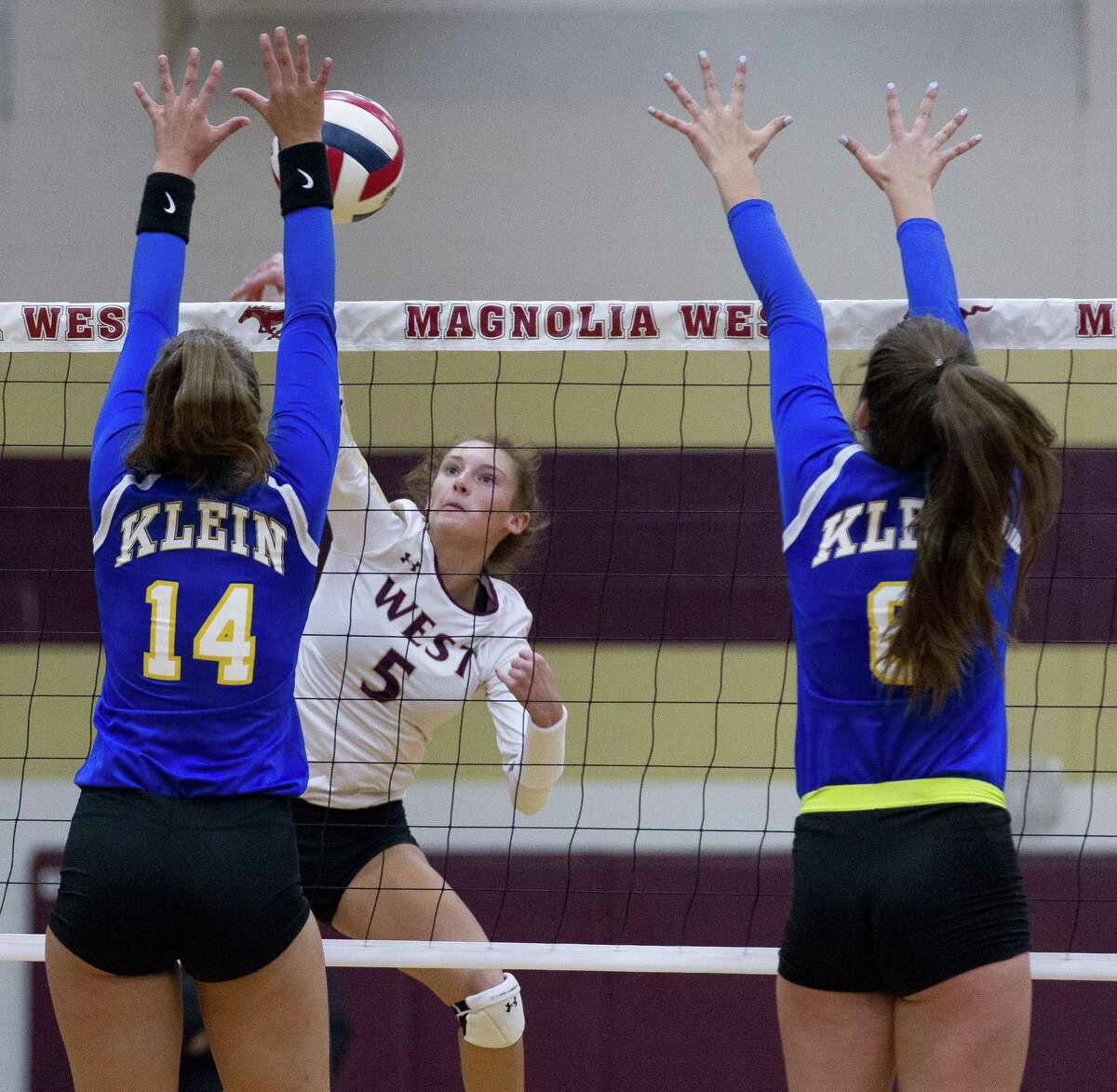 Magnolia West's Peyton Carlyle (5) goes up against Klein's Baylee Laskoskie (14) and Kalee Cadwell (6) during the first set of a non-district volleyball match at Magnolia West High School on Wednesday, Aug. 15, 2018, in Magnolia