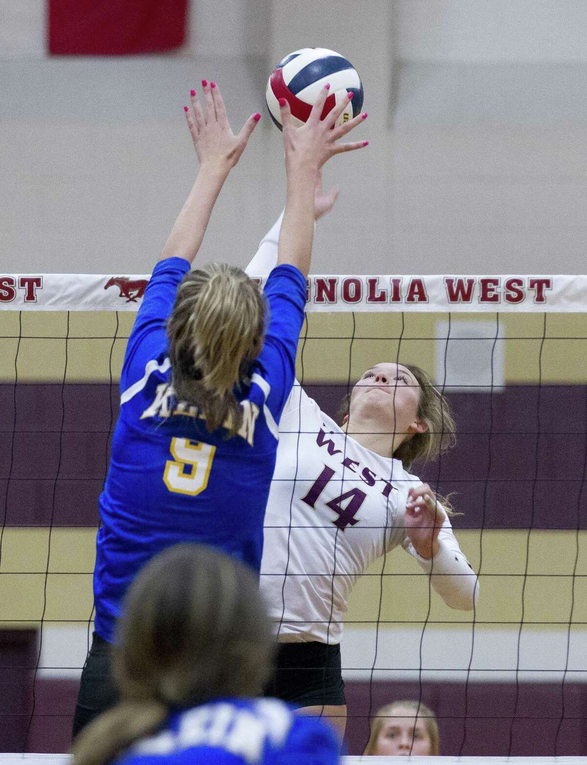 Magnolia West's Kyndall Eddlemon (14) goes up against Klein's Kierstyn McFall (9) during the first set of a non-district volleyball match at Magnolia West High School on Wednesday, Aug. 15, 2018, in Magnolia