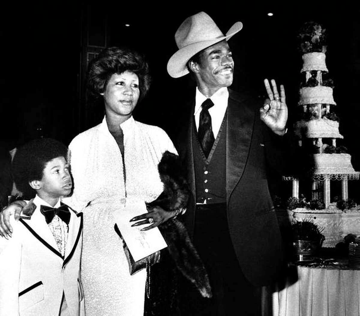In this April 17, 1978, file photo, Aretha Franklin and her new husband, Glen Turman, arrive at a Los Angeles hotel for their wedding reception. Turman signals his OK and pleasure at the reception as Kecalf 8, Aretha’s son looks on. (AP Photo/Doug Pizac, File)