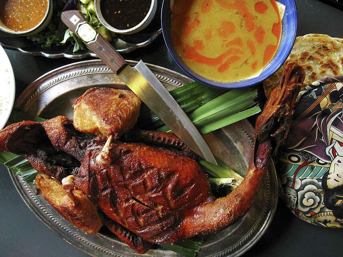 A whole crispy duck with rice, nam jim sauce, khao man gai sauce, massaman curry and paratha from Hot Joy.