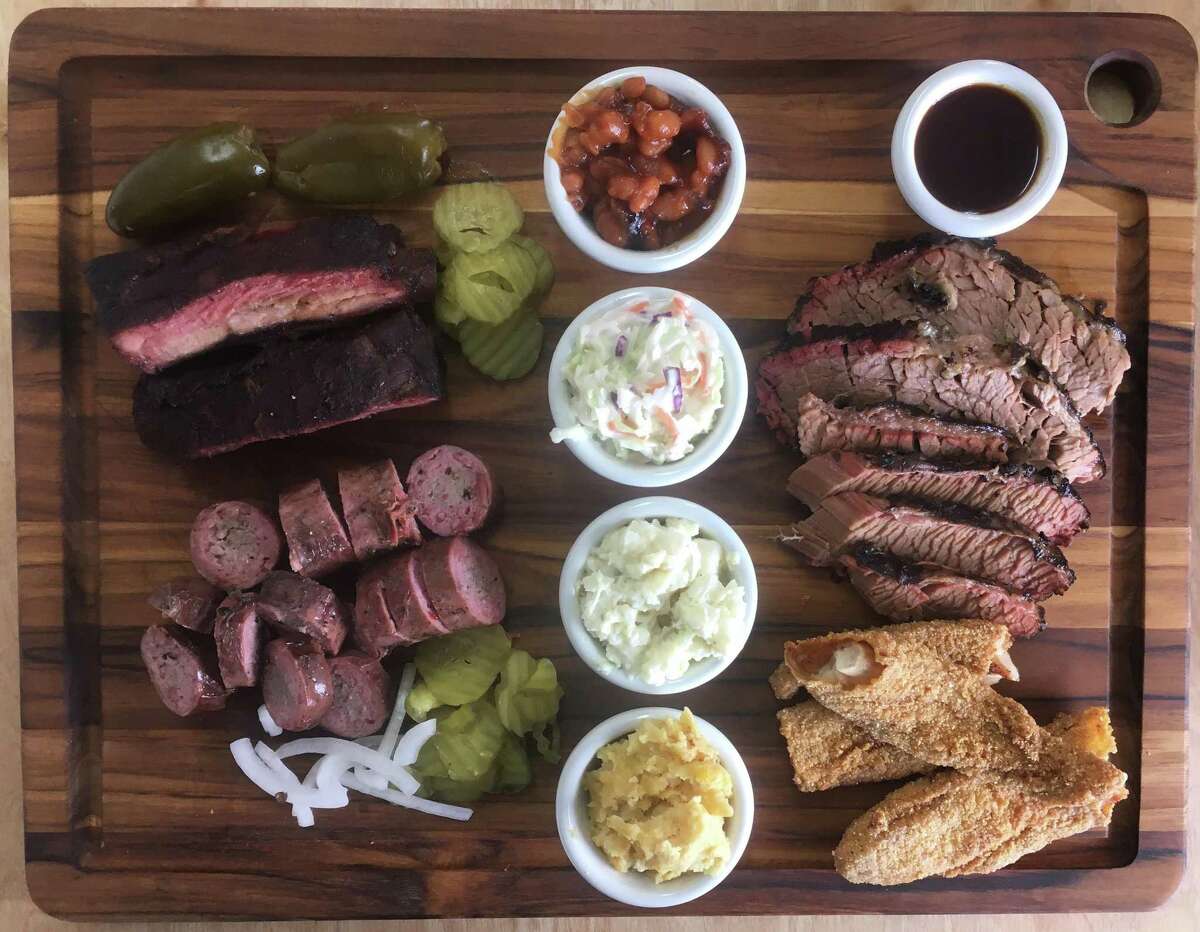 The board at 2 Sawers BBQ includes (clockwise from top left) St. Louis-style pork ribs, baked beans, marbled and lean brisket, fried catfish, corn spoonbread, potato salad, coleslaw and house beef sausage.