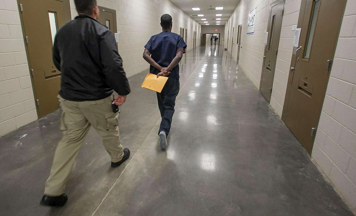 An asylum seeker is moved through the facility by a guard at the ICE Imperial Regional Detention Facility in Calexico, Calif. on Jan. 12, 2017. (John Gibbins/San Diego Union-Tribune/TNS)