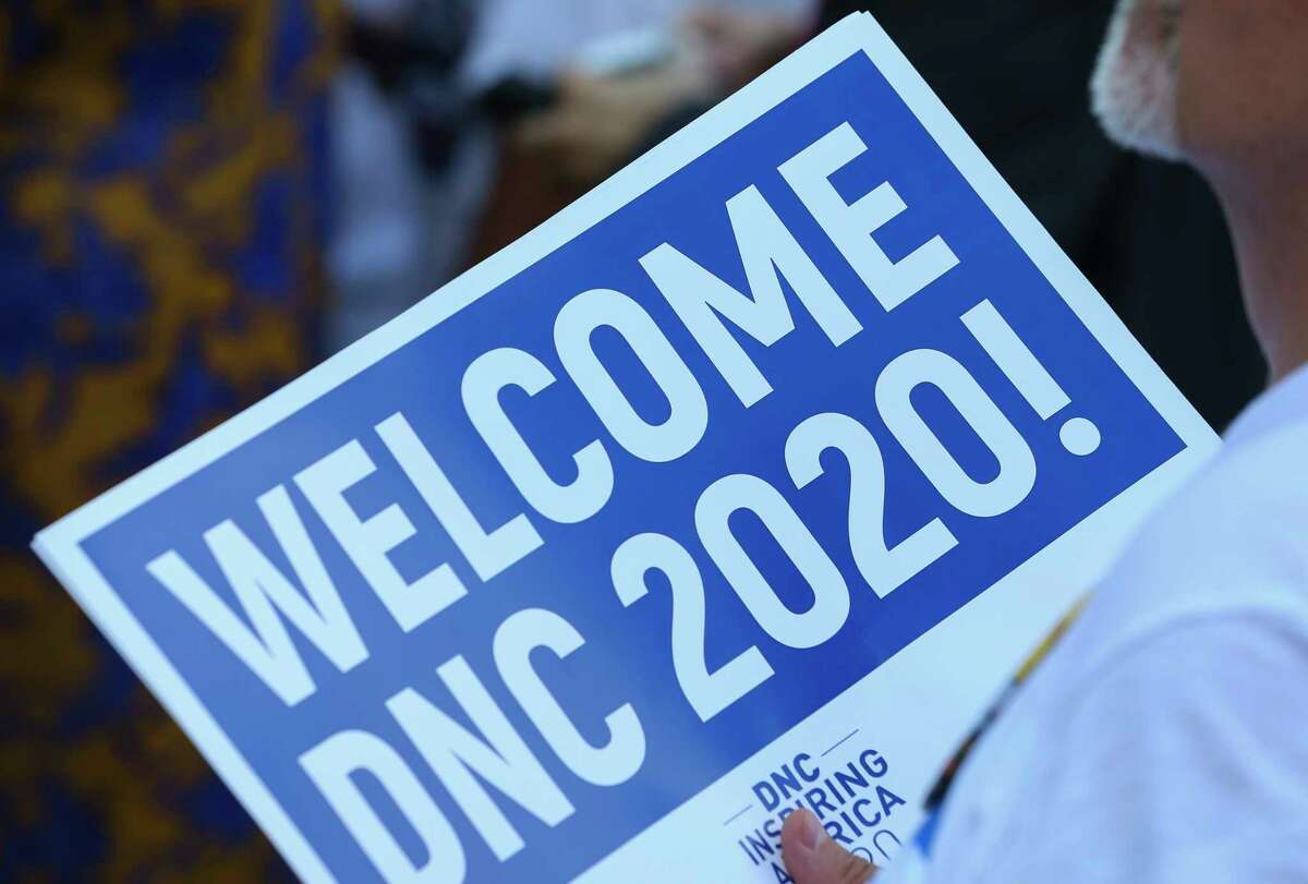 A rally participant holds a "Weolcome DNC 2020!" sign to join Houston Mayor Sylvester Turner, Houston Rockets stars James Harden and Chris Paul to welcome the Democratic National Convention 2020 Technical Advisory Group at Toyota Center on Thursday, Aug. 16, 2018, in Houston. Mayor Turner has been advocating to host the 2020 Democratic National Convention in Houston.