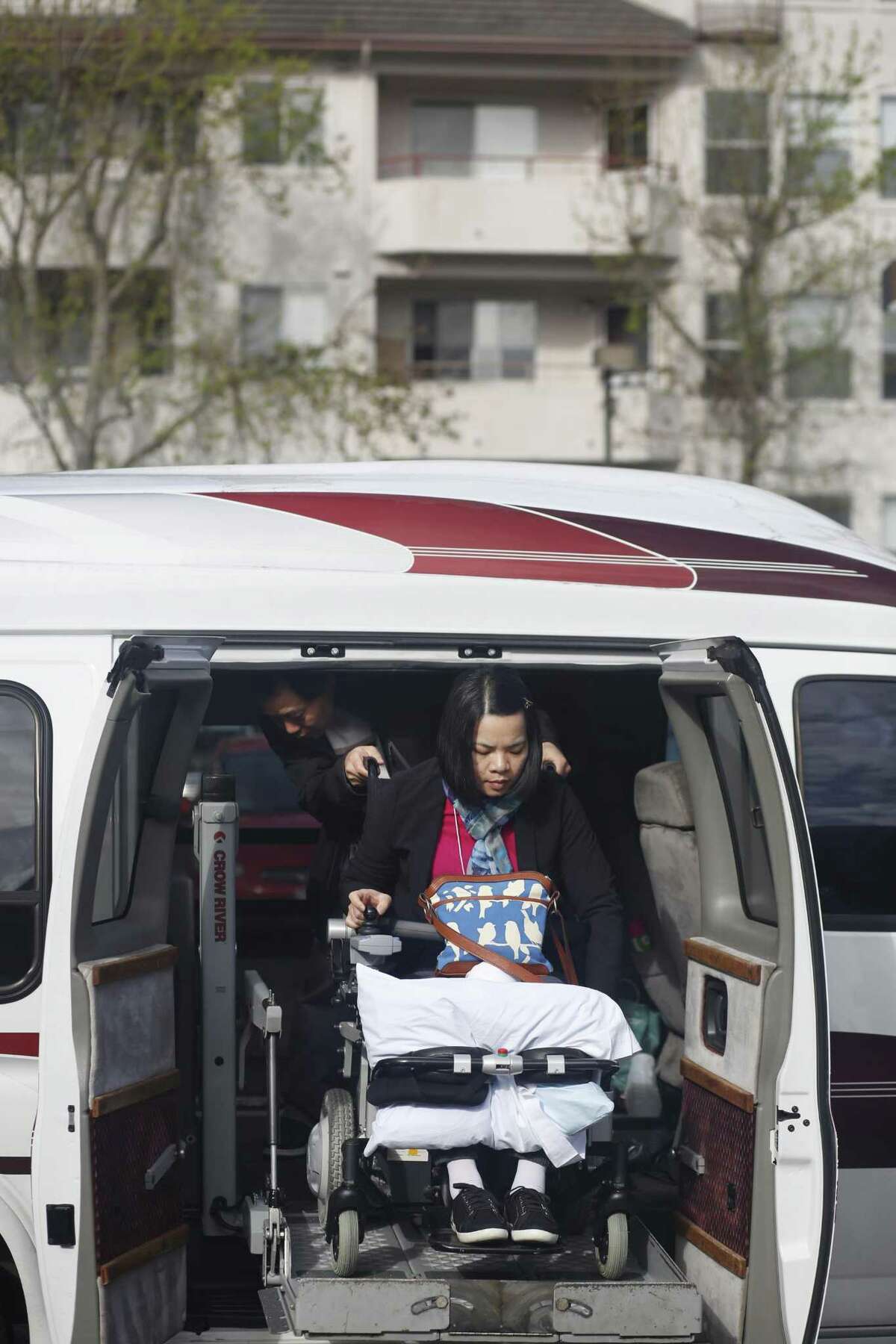 Tony Tan maneuvers wife Emma Zhou’s wheelchair as they disembark from their van to visit the Myoshinji Temple in Orinda with their family in March 2017.