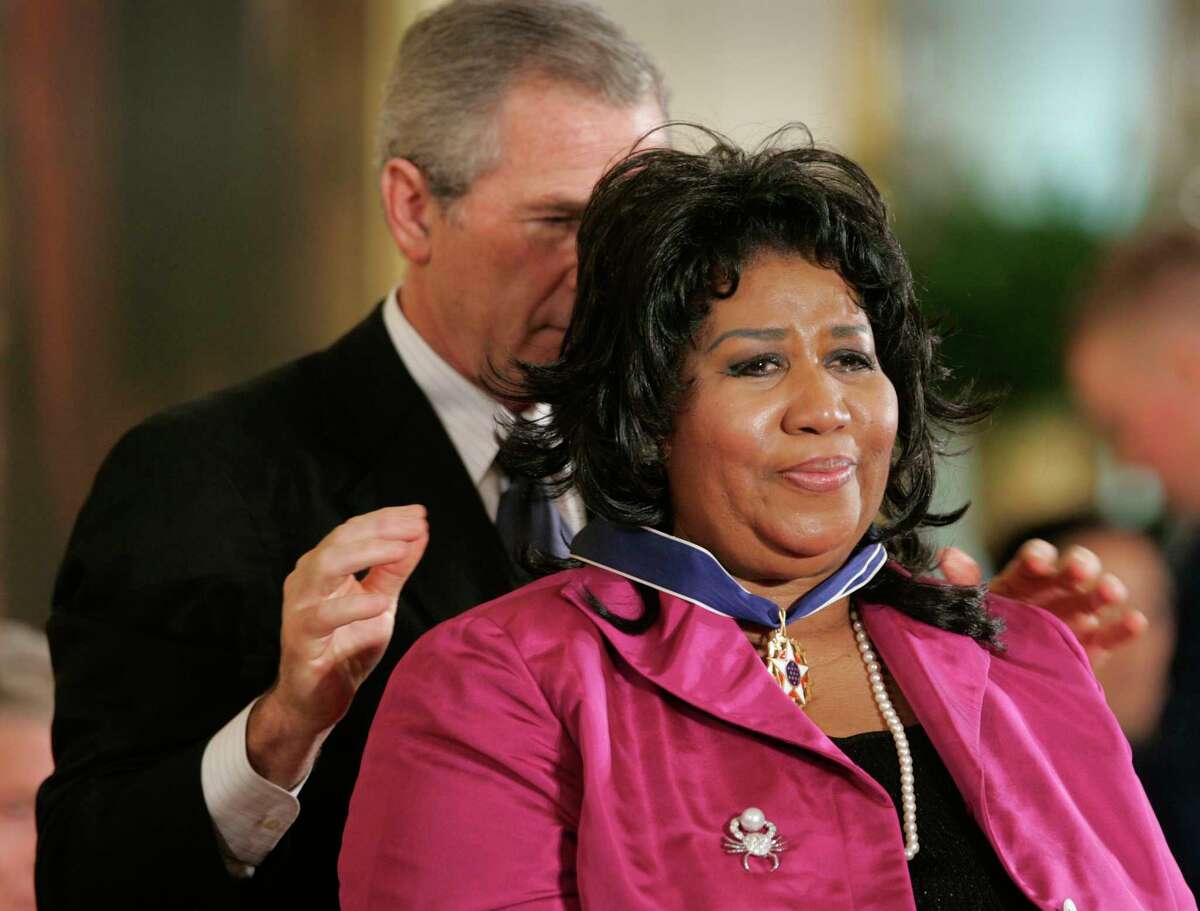 FILE - In this Nov. 9, 2005 file photo, President George W. Bush awards singer Aretha Franklin the Presidential Medal of Freedom Award, the highest civilian award, in the East Room of the White House in Washington. Franklin died Thursday, Aug. 16, 2018 at her home in Detroit. She was 76. (AP Photo/Lawrence Jackson, File)