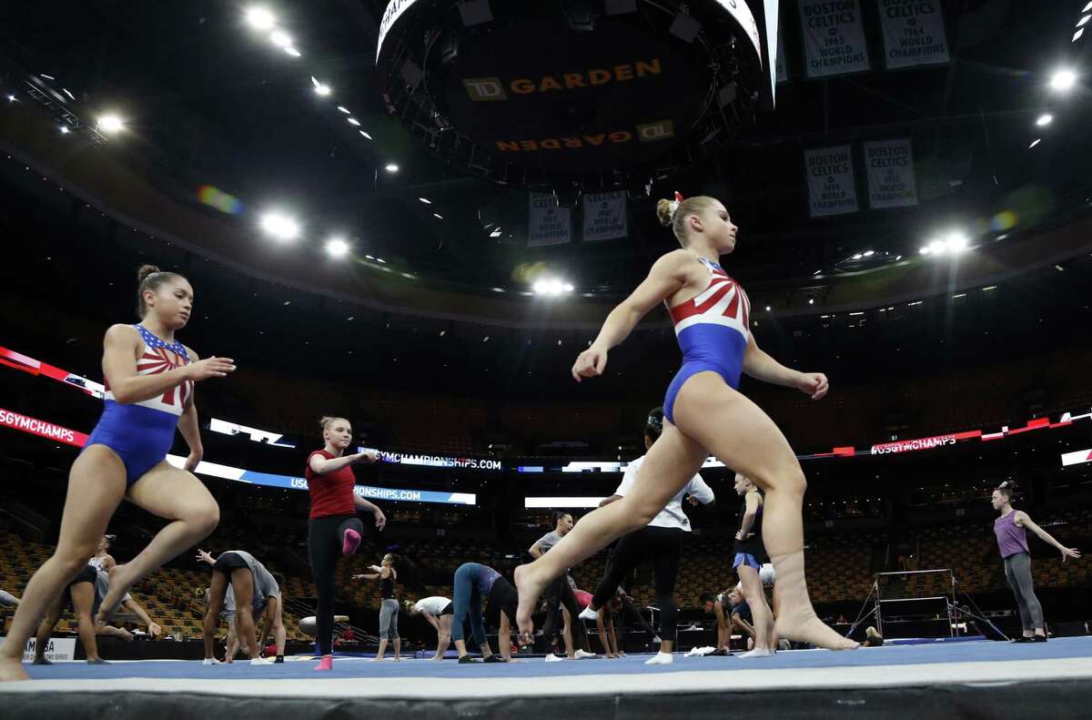Ragan Smith, right, warms up with other competitors Wednesday in advance of the USA Gymnastics national championships in Boston. The meet opened Thursday under a cloud of continued legal action.