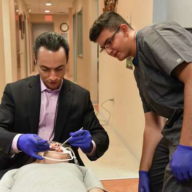 Dr. Sergey Berenshteyn, left, explains to his apprentice Joey Hayak how to put braces on the teeth of a patient at Adirondack Orthodontics on Wednesday, Aug. 8, 2018 in Latham, N.Y. (Lori Van Buren/Times Union)