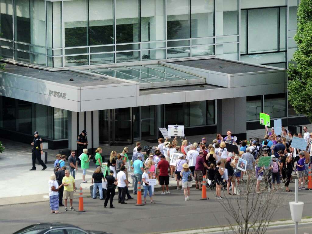 Protesters gather outside the headquarters of Purdue Pharma at 201 Tresser Blvd., in downtown Stamford, Conn., on Friday, Aug. 17, 2018.