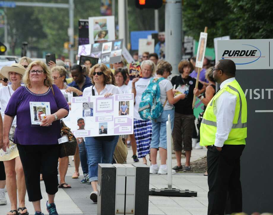 protesters march with pictures of family members who died of