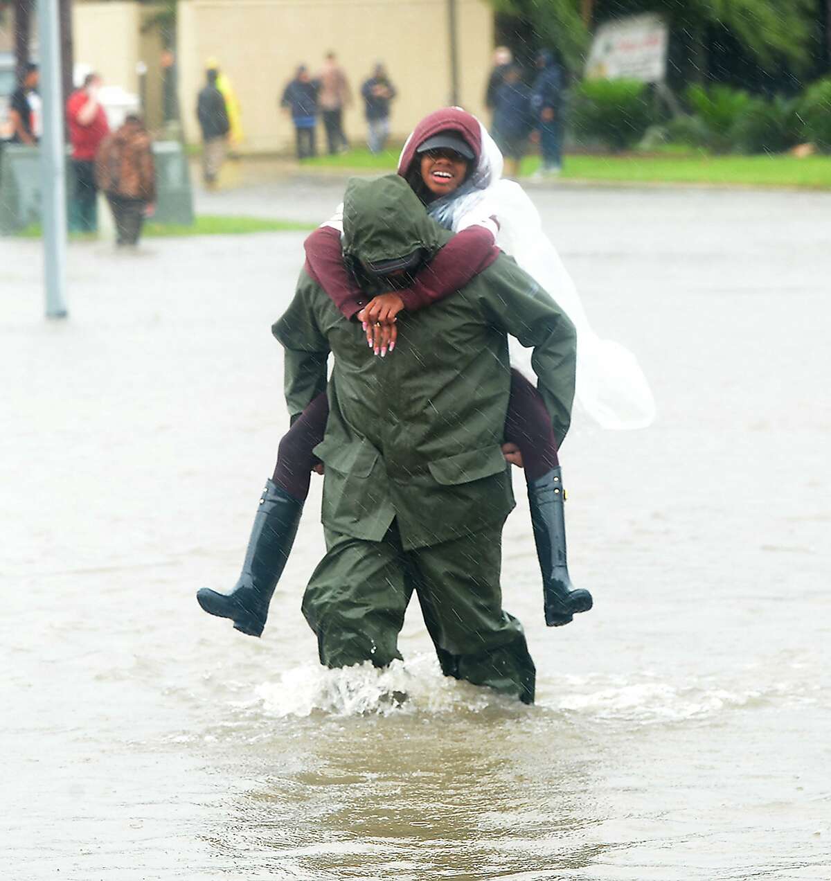 An evacuee gets a piggy back ride through the flooded waters surrounding the Max Bowl, which was converted to a shelter for those displaced by flooding in Port Arthur. Photo taken Wednesday, August 30, 2017 Kim Brent/The Enterprise