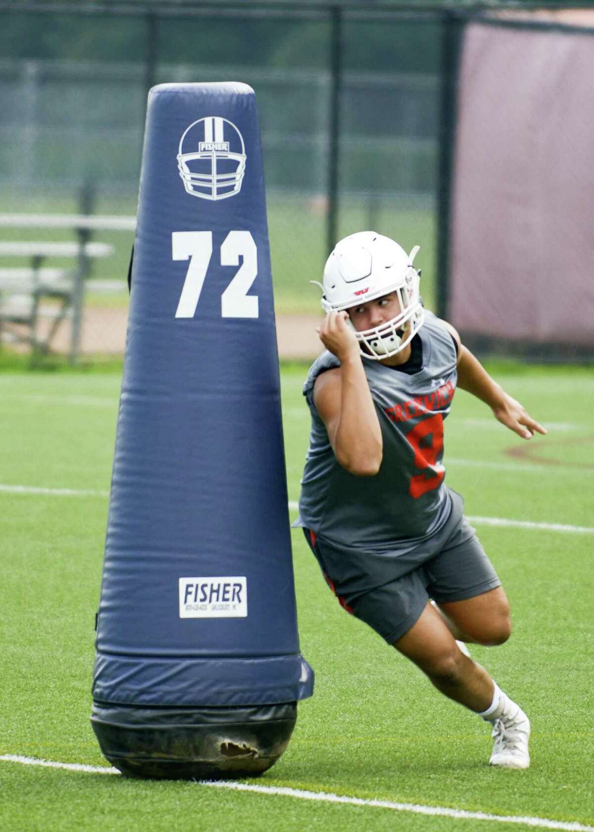 Defensive end Emilio Camou runs around a blocking dummy during a conditioning drill.