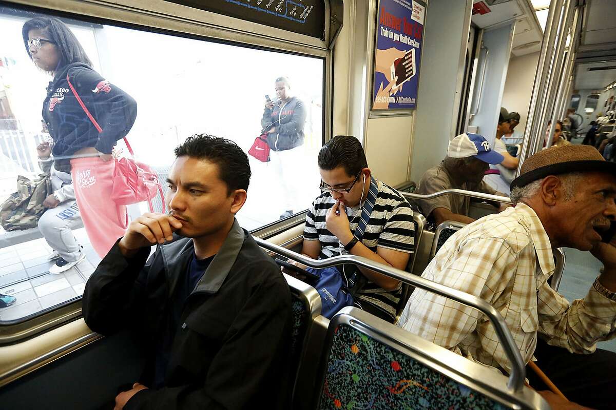 In this Feb. 15, 2017 photo, Phal Sok, left, rides the Metro Blue Line train in Los Angeles to visit with his brother in Long Beach, Calif. California Gov. Jerry Brown announced Friday, Aug. 17, 2018, he pardoned three former prisoners facing the threat of deportation to Cambodia, including Sok. Sok served 15 years for a Los Angeles County armed robbery and now works for criminal justice reform. (Genaro Molina/Los Angeles Times via AP)