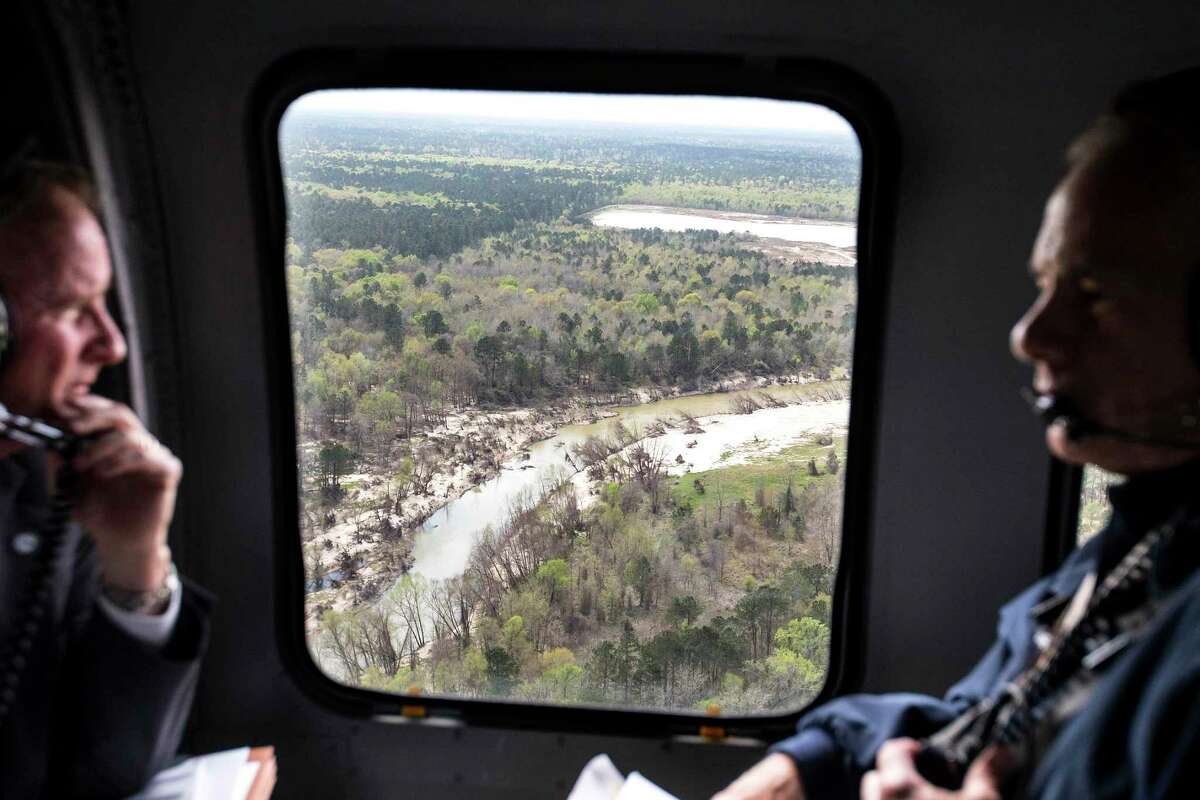 Sand can be seen piled on the banks of the San Jacinto River as Dave Martin, Houston city councilman, District E, left, and Gov. Greg Abbott take an aerial tour over the river, downstream from Lake Conroe, on Thursday, March 15, 2018, in Houston. The Kingwood area suffered serious flooding during Hurricane Harvey due in part to sand washed downstream from sand mining operations along the river. ( Brett Coomer / Houston Chronicle )