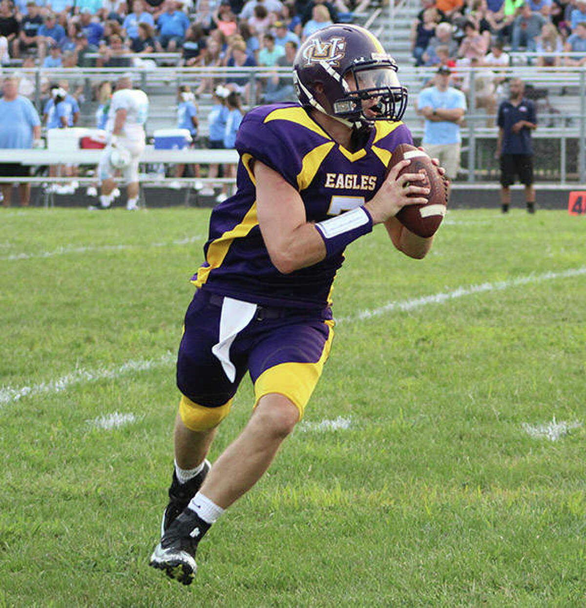 CM quarterback Tory Doerr (2008) rolls out looking for a receiver during the CM vs. Jersey alumni football game Saturday night in Bethalto.
