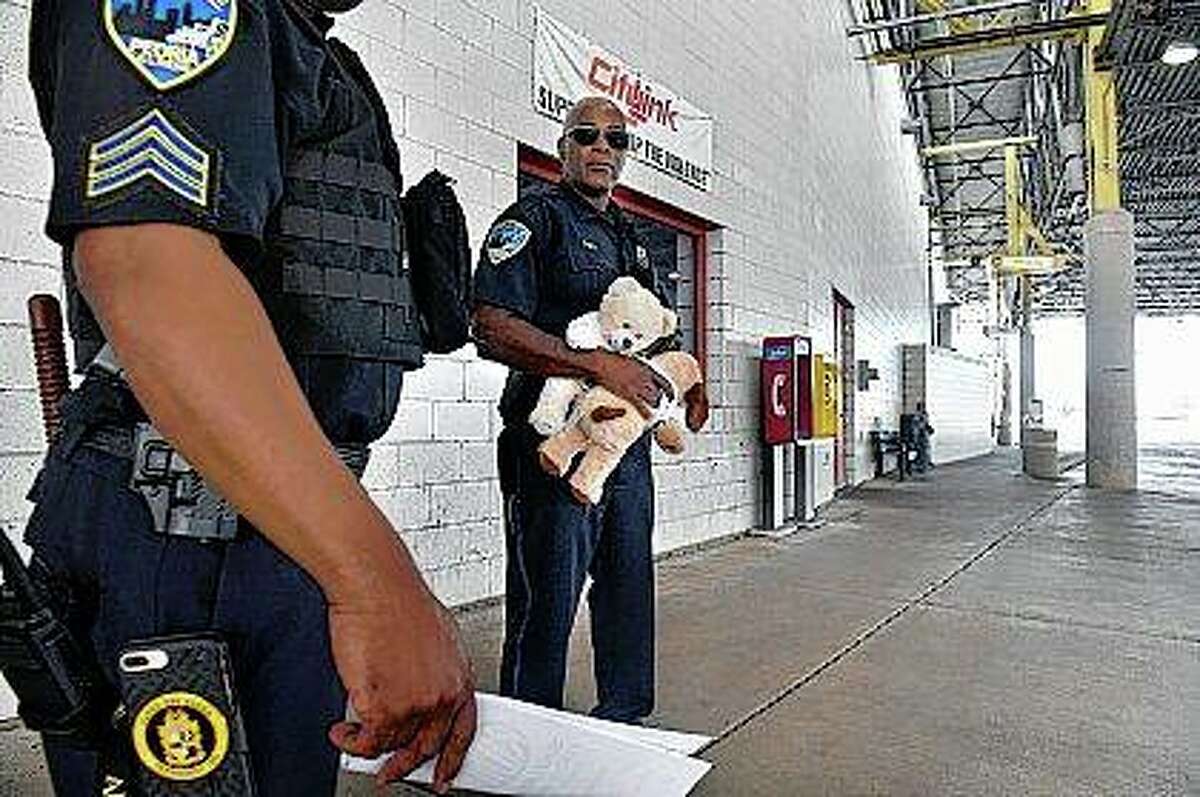 Peoria police officer Curtis Lindsay talks with another officer as he waits for buses to arrive at the CityLink Mass Transit Center to hand out stuffed animals to children. Lindsay has been passing to stuffed animals to children he encounters for the past year while on his rounds.