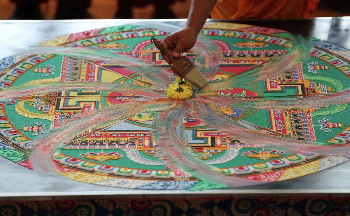 Tibetan Buddhist monks from Drepung Loseling Monastery perform a special dismantle of the mandala sand painting Sunday, Aug. 19, 2018, in Houston. The ritual was held at the Asia Society Texas Center, where the sweeping up the sands was to symbolize the impermanence of life. The mandala sand painting ritual used millions of grains of sand that were meticulously placed in order to purify and heal the environment and its inhabitants. The sand was distributed to the audience at the conclusion of the ceremony, while supplies last.
