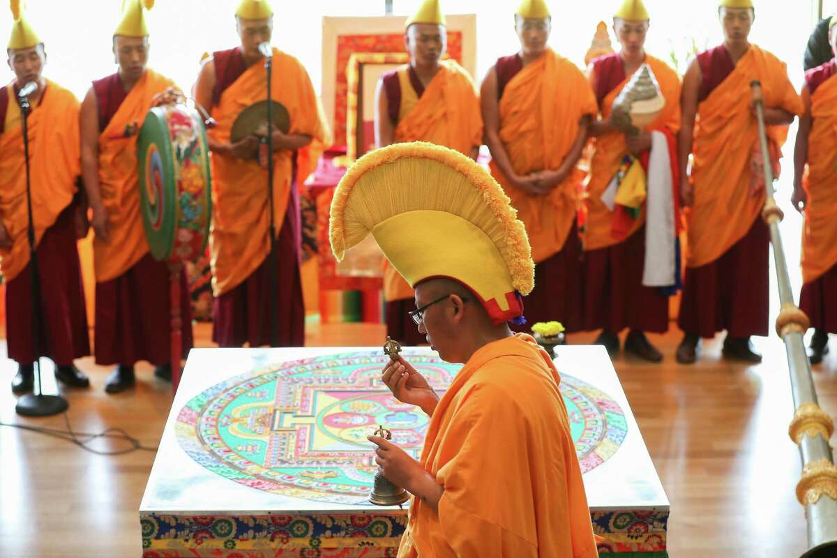 Tibetan Buddhist monks from Drepung Loseling Monastery perform a special dismantle of the mandala sand painting Sunday, Aug. 19, 2018, in Houston. The ritual was held at the Asia Society Texas Center, where the sweeping up the sands was to symbolize the impermanence of life. The mandala sand painting ritual used millions of grains of sand that were meticulously placed in order to purify and heal the environment and its inhabitants. The sand was distributed to the audience at the conclusion of the ceremony, while supplies last.