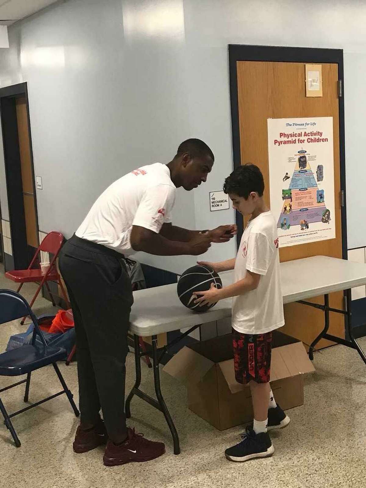 Former UConn coach Kevin Ollie signs an autograph during a charity event in Gales Ferry. (Jeff Jacobs/Hearst Connecticut Media Group )