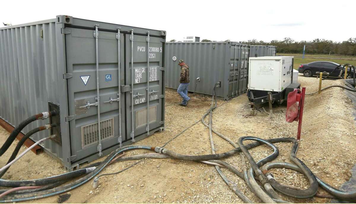 Austin Braudaway walks Dec. 5, 2017 between two of Challenger Water Solutions' containers that house the company's portable water recycling system. Consisting of two containers that do the actual water cleaning and a third container used as a control room, the entire system can be transported on two semi trucks. The system, primarily focused on oil fracking operations at the moment, is price competitive with pumping ground water according to the company.