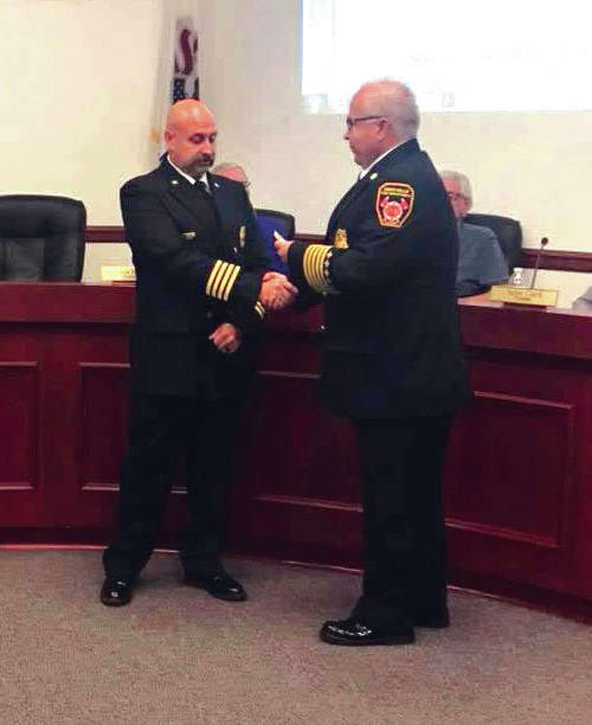 Maryville Fire Chief Kevin Flaugher, right, presents George May with his Deputy Fire Chief badge at the last regular meeting of the Maryville Board of Trustees . May was appointed to serve as the full-time Deputy Chief of the Maryville Fire Department.