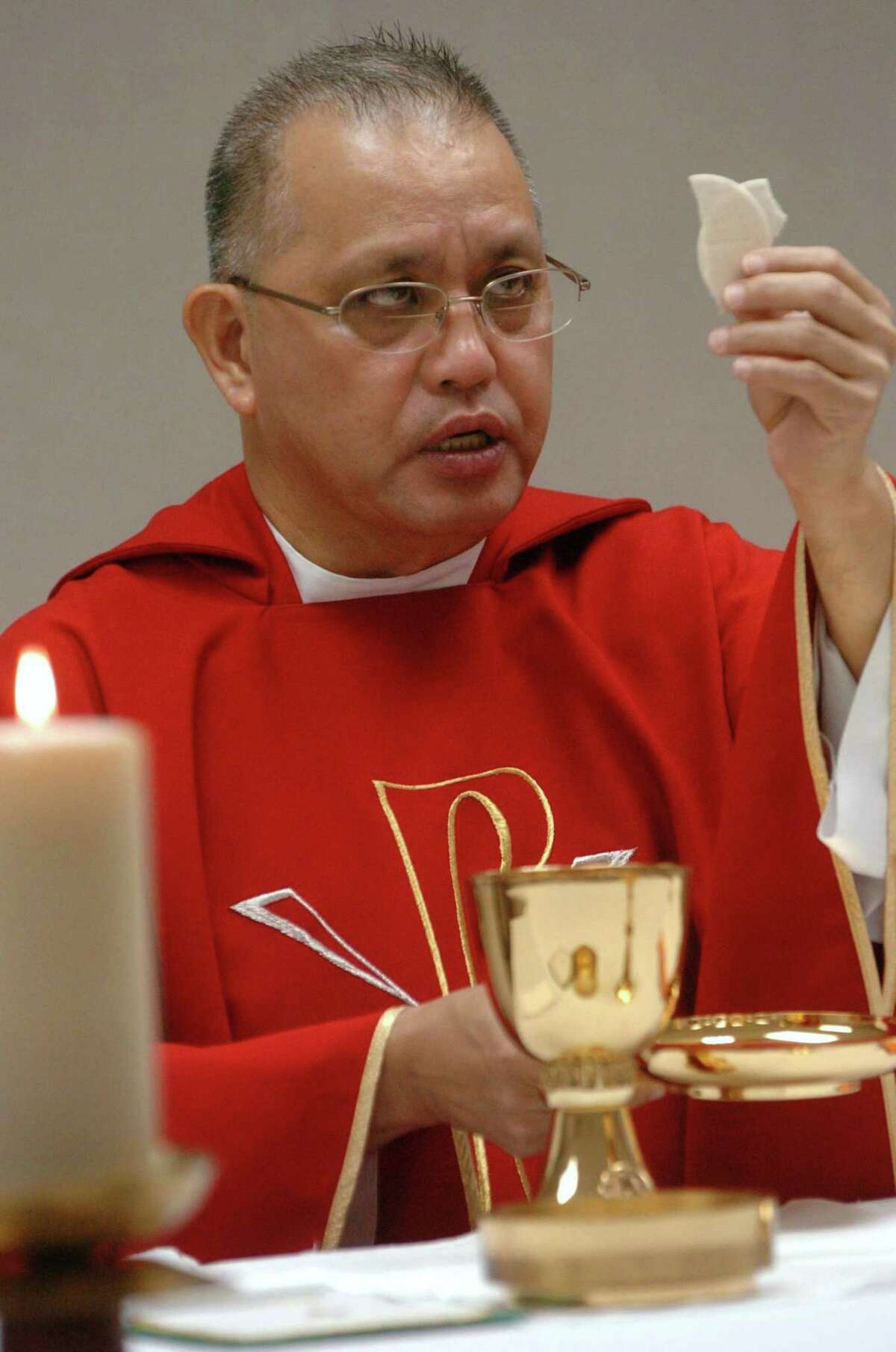 The Rev. Edmundo Paredes, in this 2008 photo, prepares for communion at St. Cecilia Catholic Church in Dallas. Paredes is accused of molesting teens and stealing from his parish.