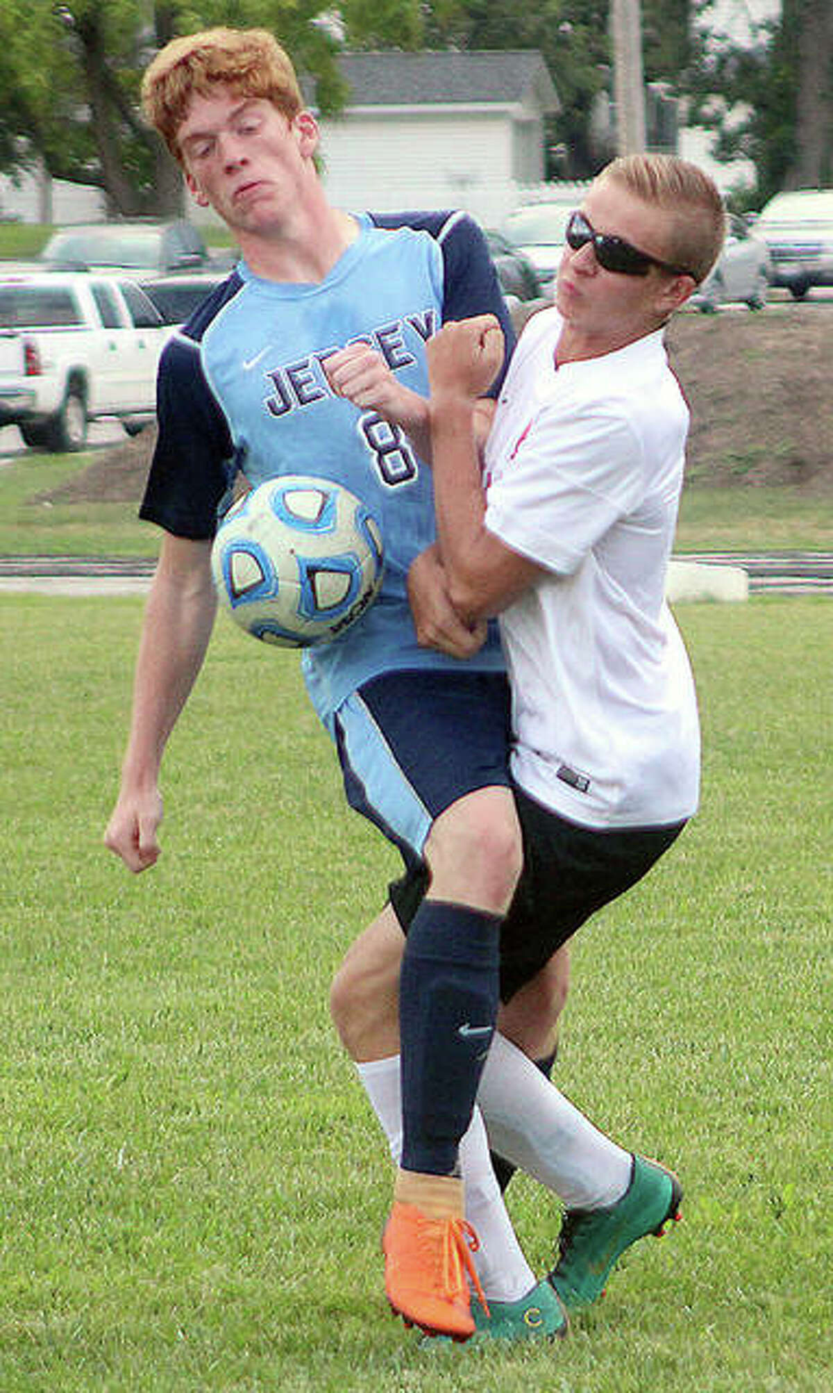 Jacob Schnefke of Staunton, right, collides with Jersey’s Zane Longley Monday in the boys prep soccer season opener in Jerseyville.