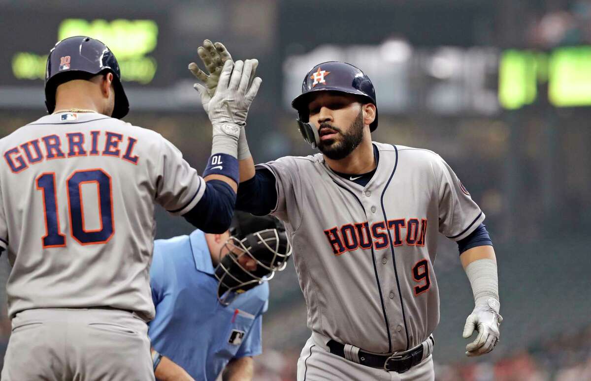Houston Astros' Marwin Gonzalez (9) is congratulated on his solo home run by Yuli Gurriel against the Seattle Mariners in the first inning of a baseball game Monday, Aug. 20, 2018, in Seattle. (AP Photo/Elaine Thompson)