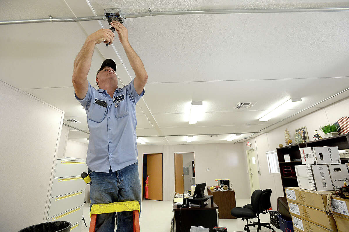 Everette Smith with Knost Electric works on installng the fire alarms in the portable office as construction continues at the new portables which will serve Vidor MIddle School sixth graders and staff at the Vidor Junior High School campus. Fifth graders will be in portables at the high school. The middle school was one of two campuses Vidor ISD lost in Harvey's flooding, and the district is still awaiting word from FEMA on how much they will receive to remodel or build anew. The 10 portable units started arriving in June, and construction crews have been putting them together within the last two weeks, doing the plumbing and electrical work and building covered walkways connecting the units. Last year, the district shuffled its two closed campuses among other school buildings, sharing rooms and other facilities in the wake of Harvey's flooding. This year, sixth graders will be at the portables, which they anticipate will be the case for at least 2 years. Monday, August 20, 2018 Kim Brent/The Enterprise