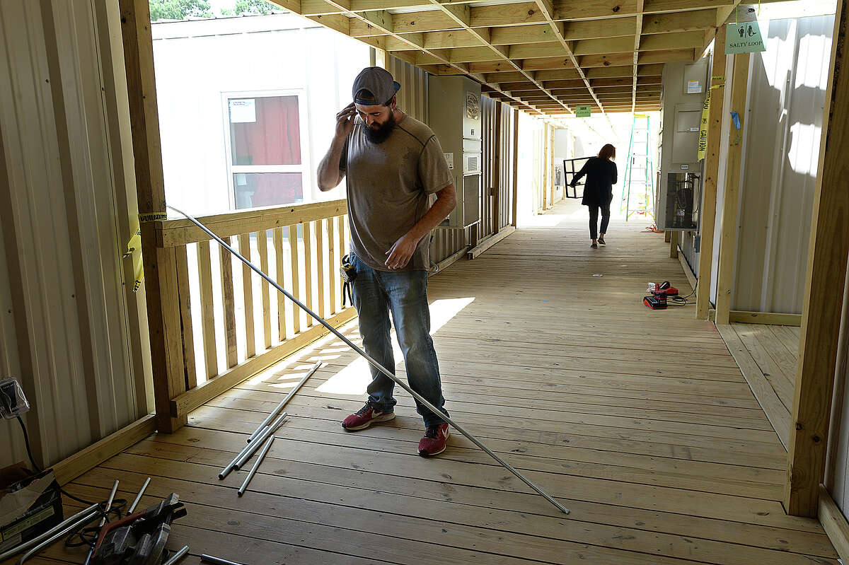 Todd Dixon with Knost Electric gets ready to cut a section of pipe as construction continues at the new portables which will serve Vidor MIddle School sixth graders and staff at the Vidor Junior HIgh School campus. Fifth graders will be in portables at the high school. The Middle School was one of two campuses Vidor ISD lost in Harvey's flooding, and the district is still awaiting word from FEMA on how much they will receive to remodel or build anew. The 10 portable units started arriving in June, and construction crews have been putting them together within the last two weeks, doing the plumbing and electrical work and building covered walkways connecting the units. Last year, the district shuffled its two closed campuses among other school buildings, sharing rooms and other facilities in the wake of Harvey's flooding. This year, sixth graders will be at the portables, which they anticipate will be the case for at least 2 years. Monday, August 20, 2018 Kim Brent/The Enterprise