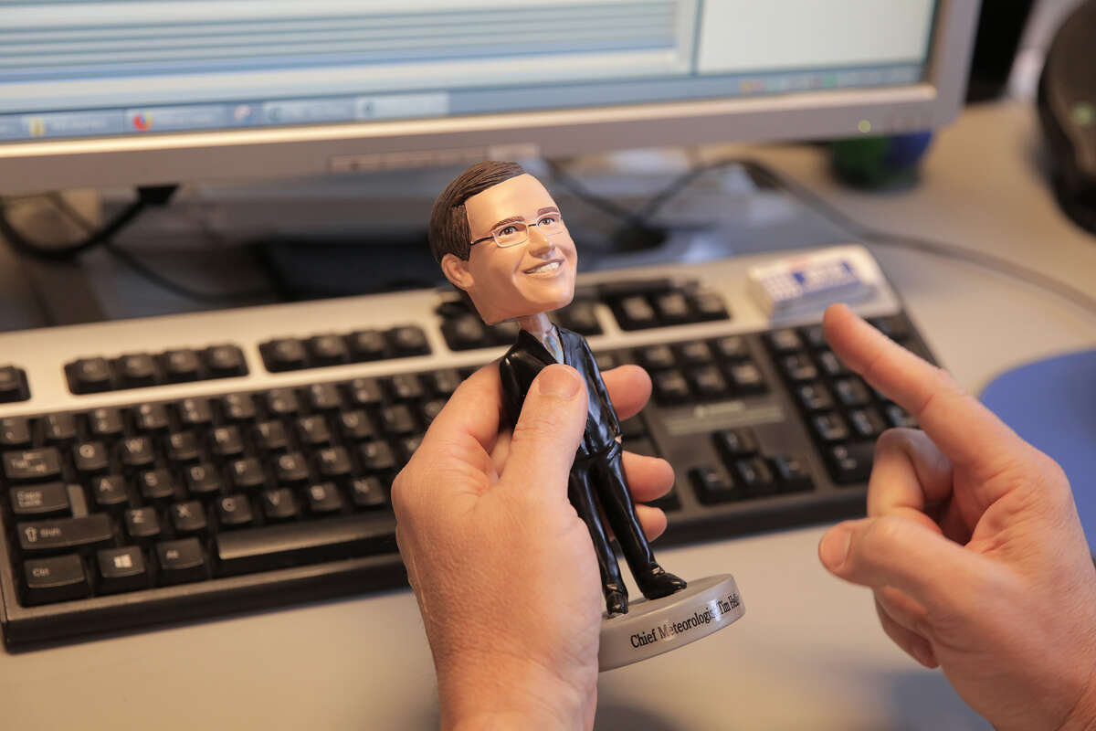 KTRK/13 chief meteorologist Tim Heller holds onto a bobble head given to him as a gift.