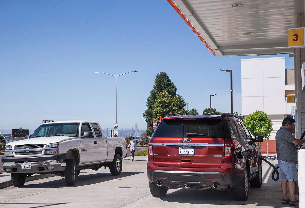 A man pumps gas into his SUV while a large truck waits its turn at the Shell station near Powell Street and West Frontage Road in Emeryville, Calif. Saturday, Aug. 4, 2018.