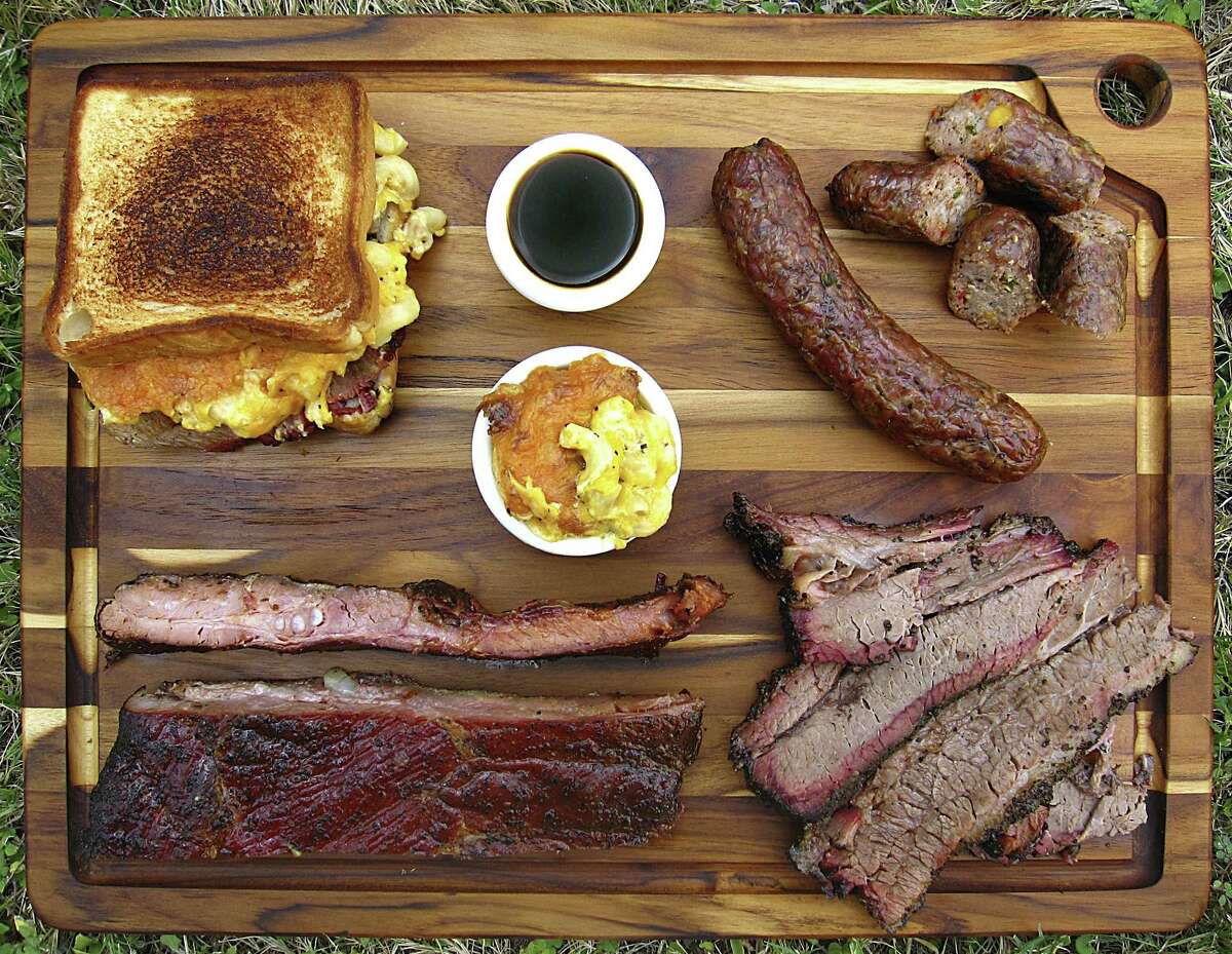 Barbecue and sides from Nelson's BBQ. Clockwise from top left: Nasty Nate sandwich with brisket and mac and cheese, barbecue sauce, handmade spicy sausage, fatty and lean brisket, pork spare ribs and macaroni and cheese.