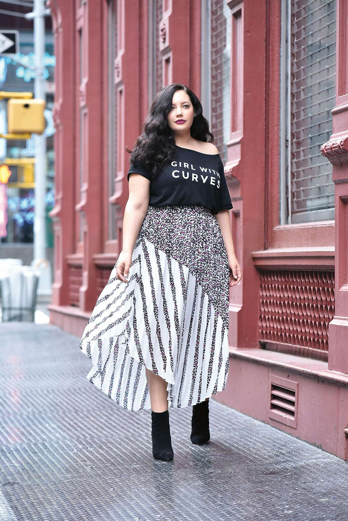 This September, Tanesha Awasthi will become the first influencer to collaborate with preeminent plus-size clothing store chain Lane Bryant. The 20-piece Girl With Curves x Lane Bryant collection features fashion-forward meets practical designs, such as a navy pleated coat that doubles as a dress and a midi-length sweater cape that looks as if it strutted straight off the runway. It will be available September 9.