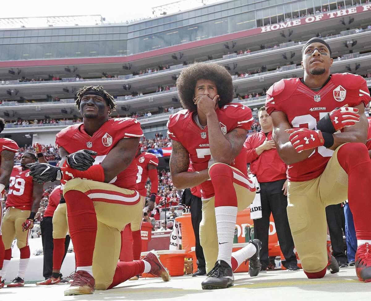 FILE - In this Oct. 2, 2016 file photo, from left, San Francisco 49ers outside linebacker Eli Harold, quarterback Colin Kaepernick and safety Eric Reid kneel in protest during the national anthem before an NFL football game against the Dallas Cowboys in Santa Clara, Calif. (AP Photo/Marcio Jose Sanchez, File)