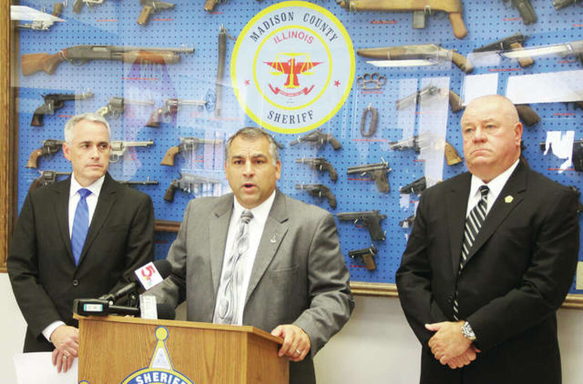 Capt. Mike Dixon of the Madison County Sheriffs Department, center, speaks during a press conference Tuesday about charges filed in the murder of a Brighton man during a Cottage Hills home invasion Aug. 16. He is flanked by Madison County States Attorney Tom Gibbons, left, and Sheriff John Lakin.