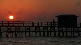 A man watches the sunrise in Rockport on a reconstructed pier. (Godofredo A. Vasquez | Houston Chronicle)