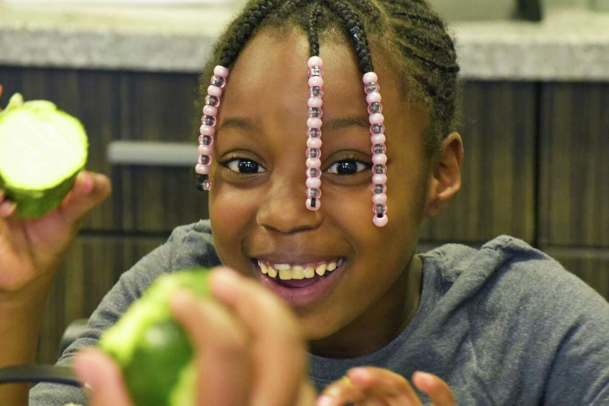 Jacearah Peters, 7, works on grating zucchini to add to pancakes at a Family Cooking Class at Unity House on Wednesday, Aug. 22, 2018, in Troy, N.Y. The family cooking classes are made possible through funding from the Ronald McDonald House Charities. (Paul Buckowski/Times Union)