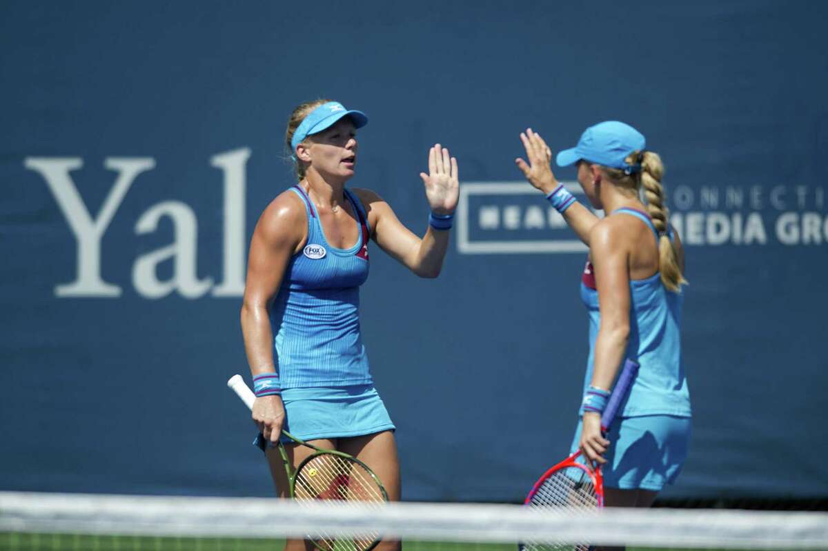 Partners Kiki Bertens, left, and Johanna Larsson high-five after winning a point during a first round doubles match against Monique Adamczak and Oksana Kalashnikova at the Connecticut Open in New Haven Wednesday. Bertens and Larsson won 6-3, 6-4.