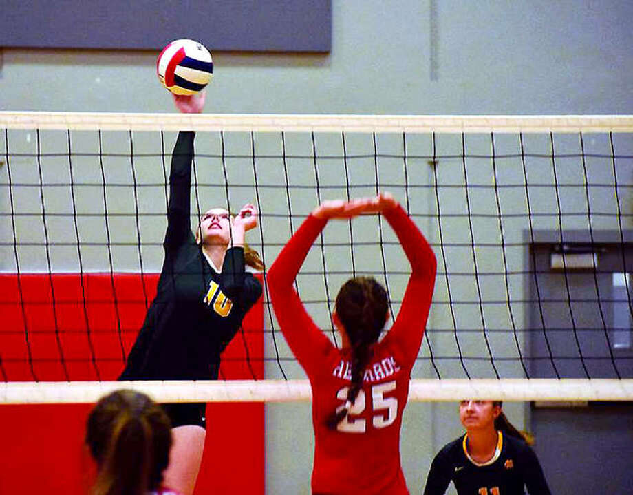 Metro-East Lutheran’s Taylor Bradley goes up for the ball Wednesday night against Alton as the Redbirds’ Brooke Wolff (25) defends. Photo: Matthew Kamp | For The Telegraph