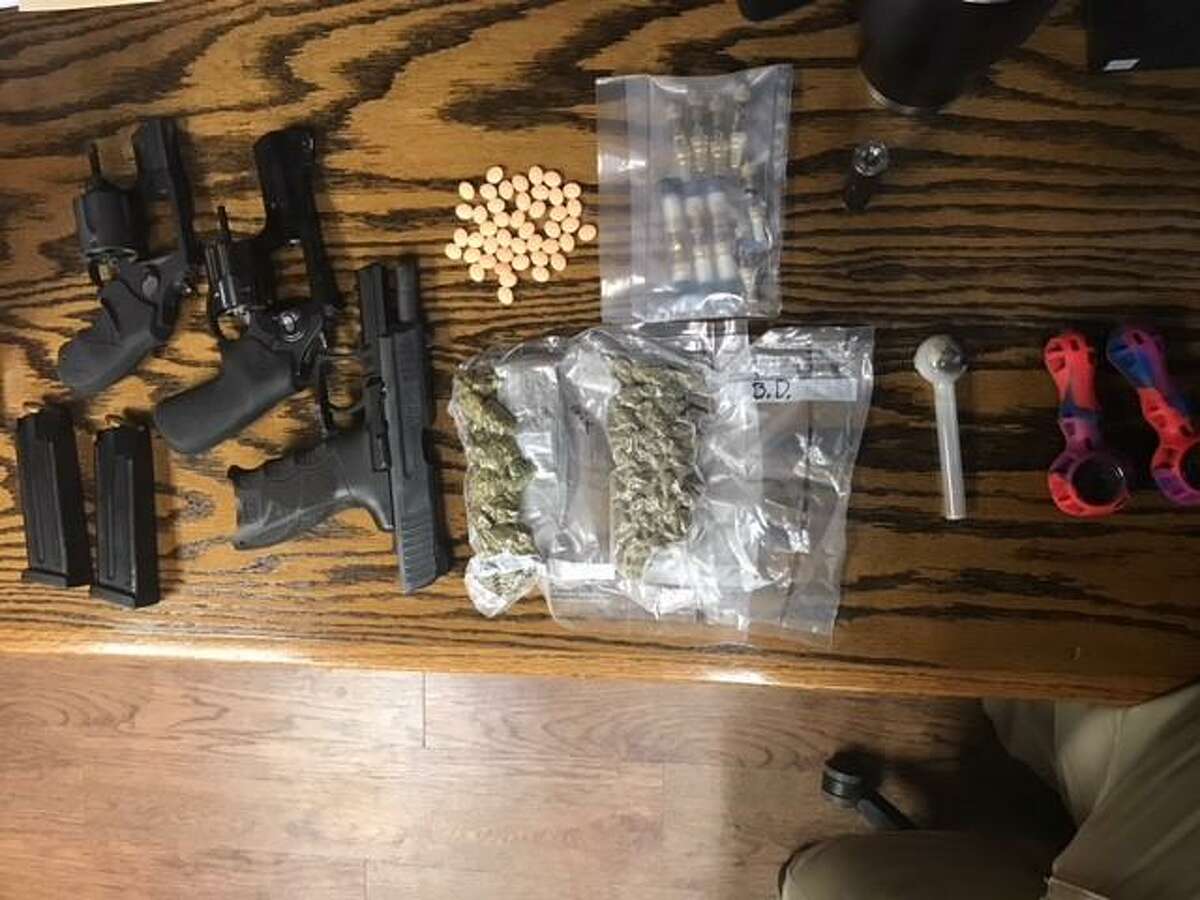 Deputies searched the vehicle and found multiple ounces of marijuana along with nine glass vials containing THC oil, over 40 prescription pills and three handguns.