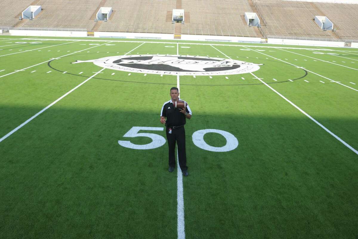 Pasadena ISD Athletic Director Rupert Jaso stands at midfield on Veterans Memorial Stadium's new turf, with the new logo in the background, one of numerous renovations for the upcoming season.